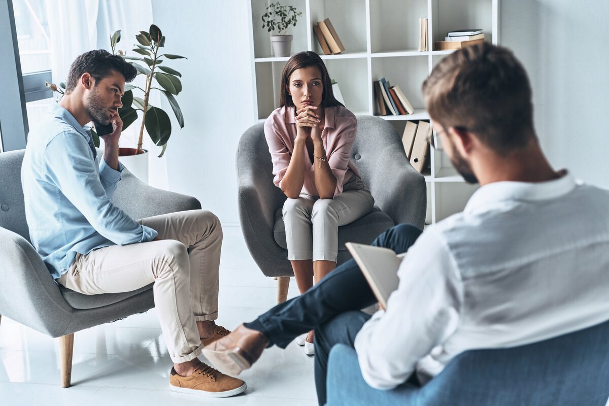 Two people seated with a mediator in a bright, informal consulting room